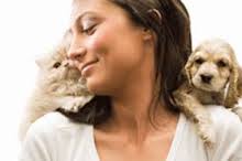 Smiling woman with cat and dog to both sides